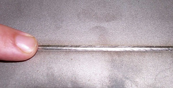 Így néz ki egy varrat, ha vékony fém fenékhegesztést hegesztenek alul lefektetett hővezető huzallal