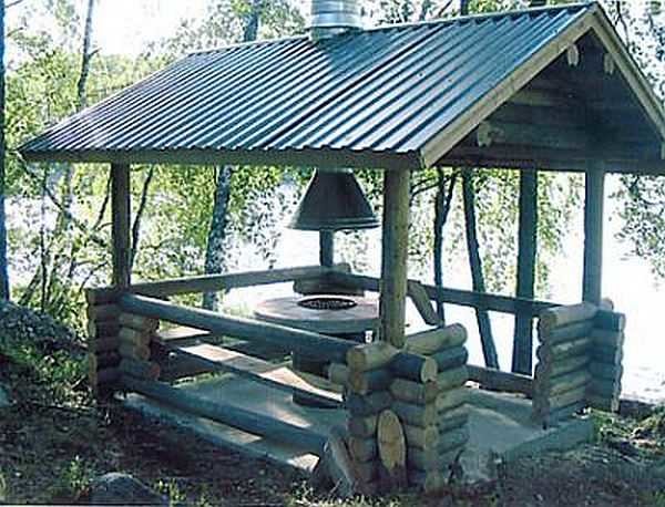 Gazebo retangular de verão feito de madeira redonda sob um telhado de duas águas
