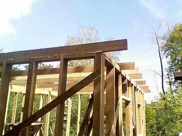 Nesta casa de madeira térrea, as vigas do piso são, ao mesmo tempo, o suporte das vigas. Portanto, eles são liberados 30 cm além do perímetro das paredes.
