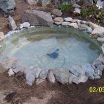 La següent etapa de fer un mini-estany per a una residència d’estiu és decorar les vores amb pedres