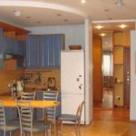Plytelės ant grindų turi skirtingas spalvas, svetainės ir virtuvės padalijimą palaiko dviejų lygių lubos