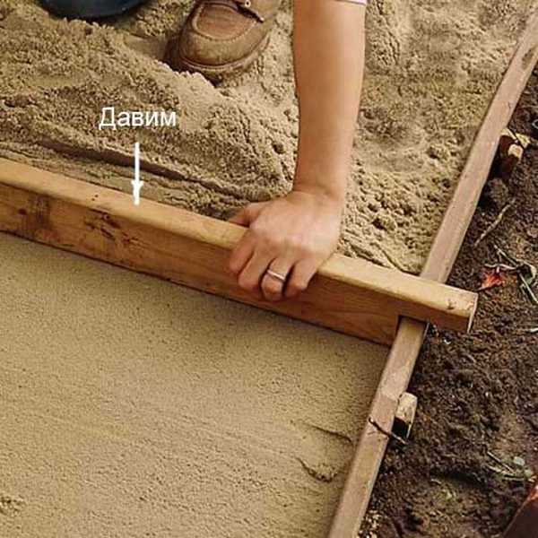 Een manier om het zand onder de loopbrug te egaliseren. Maar je moet van tevoren in de planken graven en ze waterpas zetten. Daarna maken ze zo'n plano en wordt het zand geëgaliseerd door het langs de geleiders te trekken