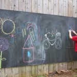 Planche d'ardoise sur la clôture - divertissement pour enfants et développement de la motricité fine des mains