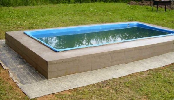 O material de cobertura é colocado no solo nivelado ao redor da piscina