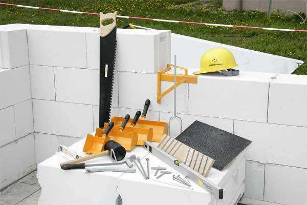Sarja työkaluja, joita tarvitaan talon rakentamiseen hiilihapotetusta betonista