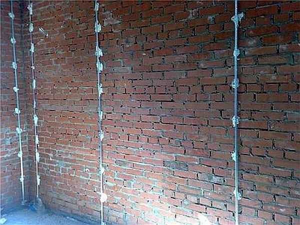 Balizas instaladas para reboco em uma parede de tijolos