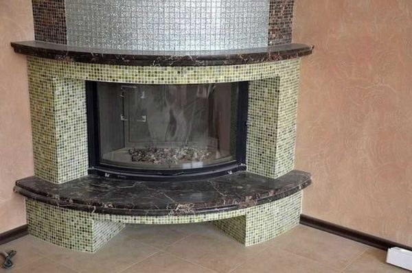 Decorar uma lareira com mosaico é especialmente bom em formas arredondadas, onde outros materiais são muito problemáticos.