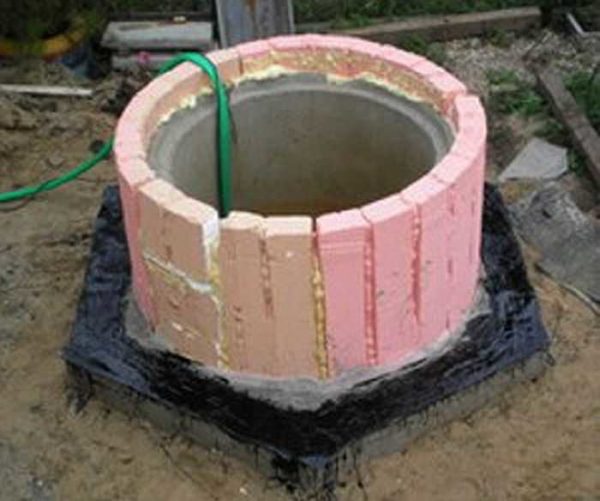 Isolera en septiktank från betongringar till markens frysning med en liten marginal (+20 cm)