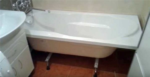A instalação de uma banheira de acrílico sobre as pernas está concluída