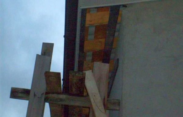 För att förhindra att byggnadsställningen kollapsar på husets vägg kan tvärstyckena göras med en frigöring på 20-30 cm.De tillåter inte att strukturen faller mot huset