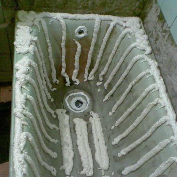 Um exemplo de aplicação de espuma sob uma inserção de banho de acrílico