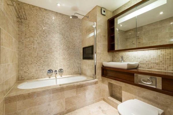 A combinação de azulejos e mosaicos é uma ótima opção para o acabamento de um banheiro