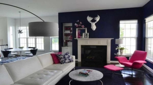 Intense cobalt blue, almost black, is the perfect backdrop for a fuchsia armchair
