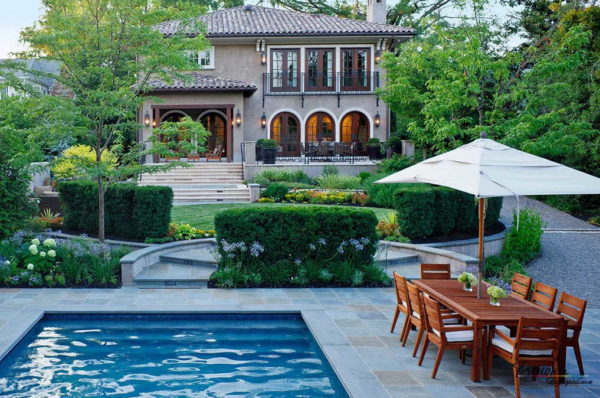 Enjardinament del pati d’una casa privada amb piscina a prop de la porta