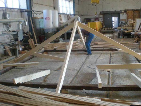 O procedimento para a montagem de um telhado de quatro inclinações: montou o arnês, prendeu as pernas da viga do meio nele
