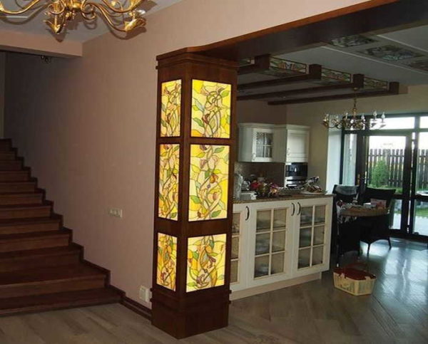 Semi-coluna com vitral com iluminação. Elementos no teto da cozinha com o mesmo ornamento